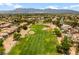 Expansive aerial view of a lush green golf course with scenic mountain backdrop and desert landscaping at 7920 Aspect Way, Las Vegas, NV 89149