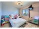 Bright bedroom with a plush rug, window, mounted TV and storage units at 7928 Violet Dawn St, Las Vegas, NV 89149