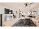 Bright and open living room with tile flooring, ceiling fan, and contemporary decor with a large TV for entertaining at 7928 Violet Dawn St, Las Vegas, NV 89149