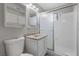 White bathroom featuring a toilet, sink with vanity, and a shower with glass doors at 808 Reynolds Ave, North Las Vegas, NV 89030
