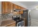 Kitchen with stainless steel appliances, tiled backsplash and wooden cabinets at 808 Reynolds Ave, North Las Vegas, NV 89030
