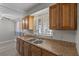 Well-lit kitchen featuring wooden cabinets, double sink and granite countertops at 808 Reynolds Ave, North Las Vegas, NV 89030