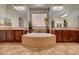 This opulent bathroom features tile flooring, dual vanities, and a large soaking tub at 8564 Mayport Dr, Las Vegas, NV 89131