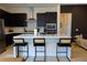 Stylish kitchen island with pendant lighting, stainless appliances, dark cabinets, and comfortable bar stools at 862 Silverton Springs St, Henderson, NV 89011