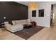 Inviting living room featuring a large sectional sofa, modern light fixture, and a dark accent wall at 862 Silverton Springs St, Henderson, NV 89011