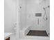 Modern bathroom with a seamless glass shower, marble tiling, and a built-in bench at 9 Porto Malaga St, Henderson, NV 89011