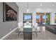 Elegant dining area with a sleek glass table, contemporary lighting, and views to the outdoor living space at 9 Porto Malaga St, Henderson, NV 89011