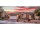 Charming single-story home featuring stone accents, a two-car garage, and mature landscaping under a vibrant twilight sky at 9 Porto Malaga St, Henderson, NV 89011