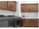Laundry room with front-loading washer/dryer and ample cabinet space at 9 Porto Malaga St, Henderson, NV 89011