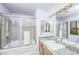 Bathroom featuring bathtub and shower with glass enclosure, granite countertop, and large mirror at 9021 Feather River Ct, Las Vegas, NV 89117