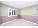 Minimalist bedroom with half-paneled wall, window with shutters, and wood-look floors at 9021 Feather River Ct, Las Vegas, NV 89117