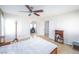 Bright bedroom with ceiling fan, light wood floors, and arched doorway leading to an office space at 9021 Feather River Ct, Las Vegas, NV 89117