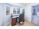 A cozy office space filled with natural light from shuttered windows, and a view to an en-suite bathroom at 9021 Feather River Ct, Las Vegas, NV 89117