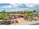 Aerial view showcasing the home, circular driveway, mature palms, and a mountain backdrop at 9111 W Stephen Ave, Las Vegas, NV 89149