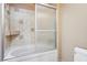 Bathroom showing a combined tub and shower with sliding glass doors and neutral patterned tile surround at 9111 W Stephen Ave, Las Vegas, NV 89149