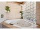 Bright bathroom features a jetted tub with a tiled wall and a glass block window at 9111 W Stephen Ave, Las Vegas, NV 89149
