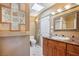 Bright bathroom featuring a vanity with granite counters, framed mirror, and a tiled glass block accent wall at 9111 W Stephen Ave, Las Vegas, NV 89149