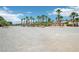 Expansive lot with desert landscaping, palm trees, and a single-story home under a partly cloudy sky at 9111 W Stephen Ave, Las Vegas, NV 89149
