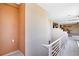 Bright hallway with neutral walls and a white railing, leading to living area and rooms beyond at 9111 W Stephen Ave, Las Vegas, NV 89149