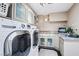 Bright laundry room with modern appliances, storage cabinets, and a granite countertop at 9111 W Stephen Ave, Las Vegas, NV 89149