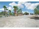 Wide, open outdoor area with palm trees, a tennis court, and storage buildings, all under a sunny sky at 9111 W Stephen Ave, Las Vegas, NV 89149