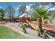 Well-maintained playground with a swing set, slide, and soft ground cover in a landscaped yard at 9111 W Stephen Ave, Las Vegas, NV 89149