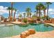 Beautiful backyard pool features rock waterfall, lush palms and relaxing seating area at 9111 W Stephen Ave, Las Vegas, NV 89149