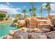 Gorgeous backyard pool features a rock waterfall and tropical foliage for a resort-like setting at 9111 W Stephen Ave, Las Vegas, NV 89149