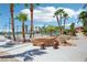 Beautifully landscaped area featuring a tennis court, palm trees, and a unique rock seating area at 9111 W Stephen Ave, Las Vegas, NV 89149