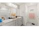 Bathroom features double sinks, gray cabinets, granite countertops, and a shower over tub at 9161 Rolling Sky Dr, Las Vegas, NV 89178