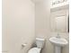 Simple powder room with a pedestal sink, standard toilet, and a large mirror at 9161 Rolling Sky Dr, Las Vegas, NV 89178