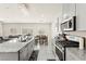 Contemporary kitchen with stainless steel appliances, gray cabinets, granite counters and an open floor plan at 9161 Rolling Sky Dr, Las Vegas, NV 89178