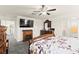 Bright main bedroom featuring an entertainment center, ceiling fan, and ensuite bathroom at 9161 Rolling Sky Dr, Las Vegas, NV 89178