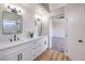 Bathroom featuring dual sinks with quartz countertops, modern fixtures, and access to the bedroom at 9321 Dancing Daffodil Ave, Las Vegas, NV 89129