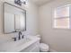 Powder bathroom featuring white vanity, matte black faucet, framed mirror, and modern lighting at 9321 Dancing Daffodil Ave, Las Vegas, NV 89129