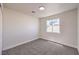 A well-lit carpeted bedroom with neutral walls, a window, and base trim at 9321 Dancing Daffodil Ave, Las Vegas, NV 89129