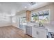 Bright kitchen features wood-look floors, white cabinets, stainless steel appliances, and a large garden window at 9321 Dancing Daffodil Ave, Las Vegas, NV 89129