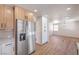 Open kitchen with stainless steel refrigerator and a view of the dining area with wood-look flooring at 9321 Dancing Daffodil Ave, Las Vegas, NV 89129