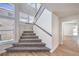 Bright foyer with carpeted stairs, dark metal railings, and large windows, filling the space with natural light at 9321 Dancing Daffodil Ave, Las Vegas, NV 89129