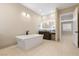 Bright bathroom with soaking tub, dark wood vanity with granite counters, and access to the main bedroom at 9865 Bright Angel Way, Las Vegas, NV 89149