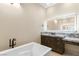 Bathroom featuring a soaking tub, dark wood vanity with granite counters, and tile floors at 9865 Bright Angel Way, Las Vegas, NV 89149