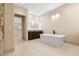 Bathroom featuring a soaking tub, dark wood cabinets, granite counters and tile floors at 9865 Bright Angel Way, Las Vegas, NV 89149