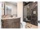 Modern bathroom featuring granite counters, a dark wood vanity, and a luxurious glass enclosed shower with sleek fixtures at 9865 Bright Angel Way, Las Vegas, NV 89149