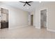 Bright bedroom with a ceiling fan, featuring tile floors, and ensuite bathroom at 9865 Bright Angel Way, Las Vegas, NV 89149
