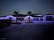 Night shot of a single-story home featuring a three-car garage, palm trees, and holiday lighting at 9865 Bright Angel Way, Las Vegas, NV 89149