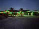Night shot of a single-story home featuring a three-car garage, palm trees, and holiday lighting at 9865 Bright Angel Way, Las Vegas, NV 89149