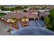 Aerial view of a home featuring desert landscaping, a tile roof, and a three-car garage at 9865 Bright Angel Way, Las Vegas, NV 89149