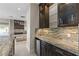 Bar area with stone countertops, glass cabinets, and stainless steel mini-fridge at 9865 Bright Angel Way, Las Vegas, NV 89149
