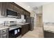 Modern kitchen featuring stainless steel appliances, dark wood cabinetry, and granite countertops at 9865 Bright Angel Way, Las Vegas, NV 89149
