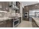Gourmet kitchen features a stainless steel range, custom cabinetry, and granite countertops at 9865 Bright Angel Way, Las Vegas, NV 89149